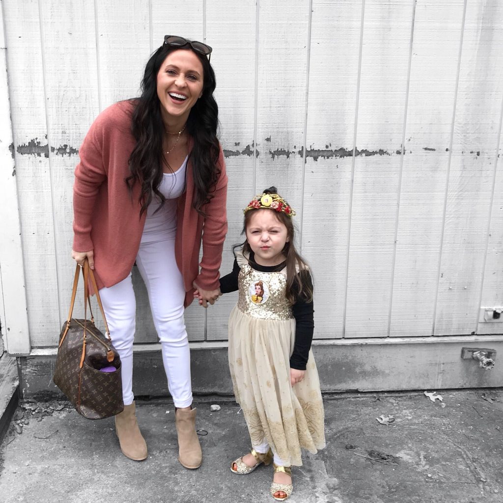 mother and daughter - mom wearing white maternity jeans, a pink cardigan, and booties