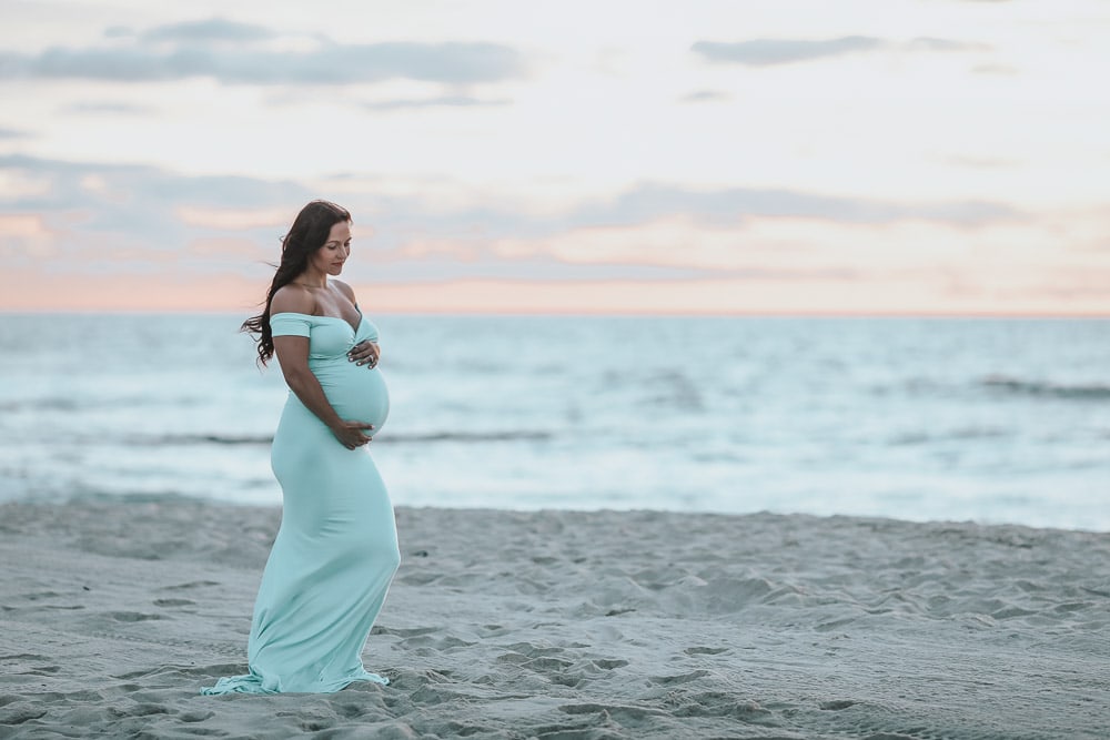 woman doing maternity photos at the beach