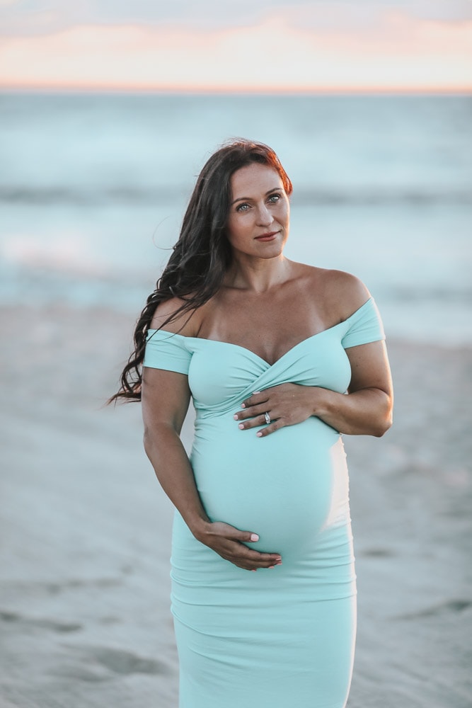 woman doing a beach maternity photoshoot