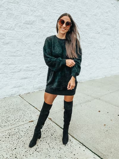 woman wearing a black sweater dress with black over the knee boots