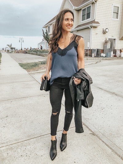 a woman wearing a blue lace cami, black jeans, and black booties