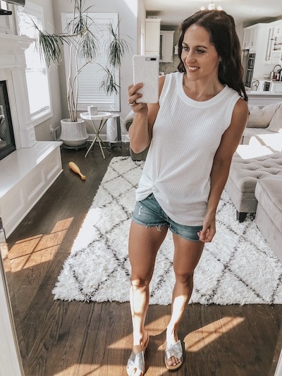 woman wearing a white knot front tank top and denim shorts from amazon