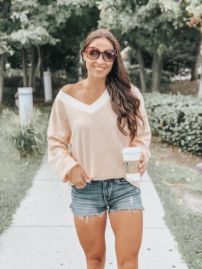 woman wearing an off shoulder blouse from amazon and denim shorts