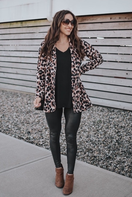 a woman wearing black leggings with a leopard cardigan