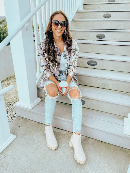 woman wearing a plaid button up, booties, and jeans