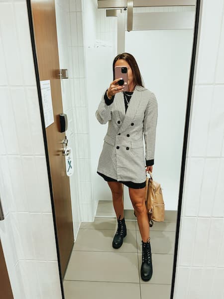 A woman in an oversized blazer outfit with black combat boots.