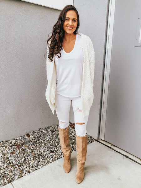 woman wearing white jeans with knee high boots