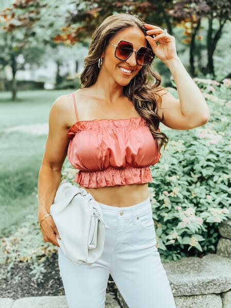woman wearing white jeans and a pink crop top