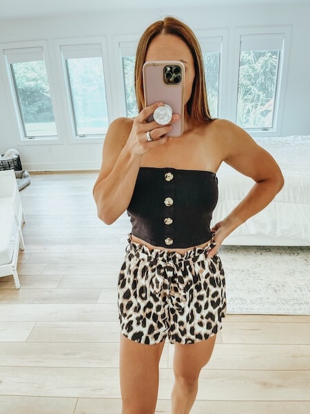 woman wearing leopard shorts and black crop top