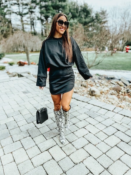 woman in black dress and snakeskin boots