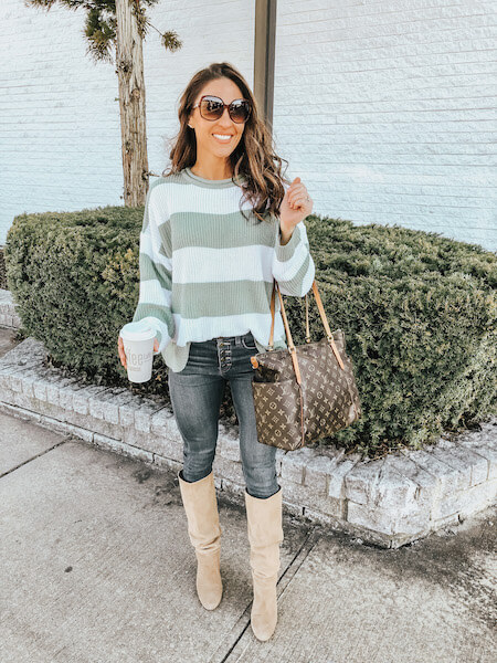 woman in green sweater and jeans with knee high boots