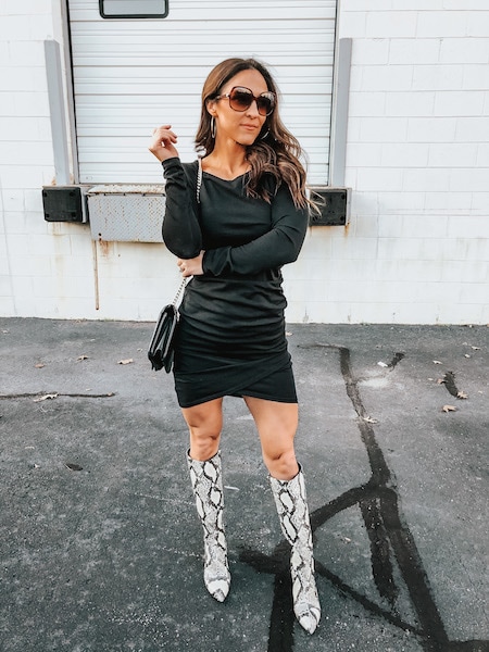A woman wearing a bodycon dress and snakeskin boots.