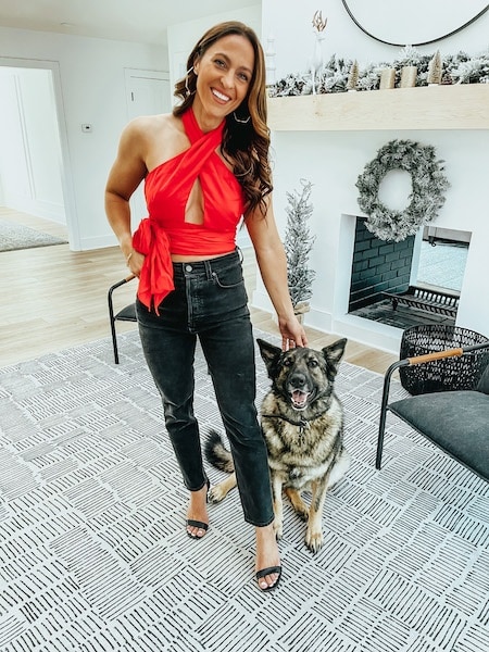 A woman wearing a red halter top from revolve.