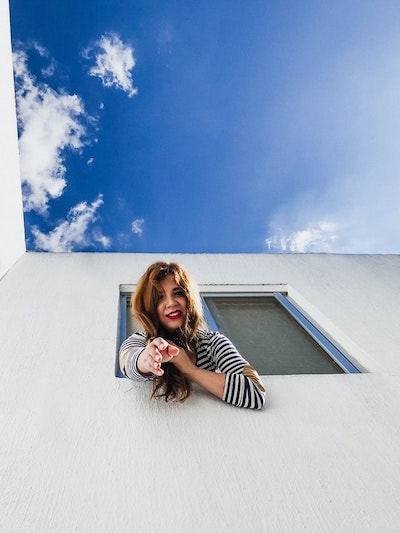 woman posing hanging out a window