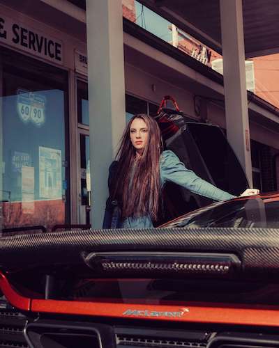 woman posing next to a car