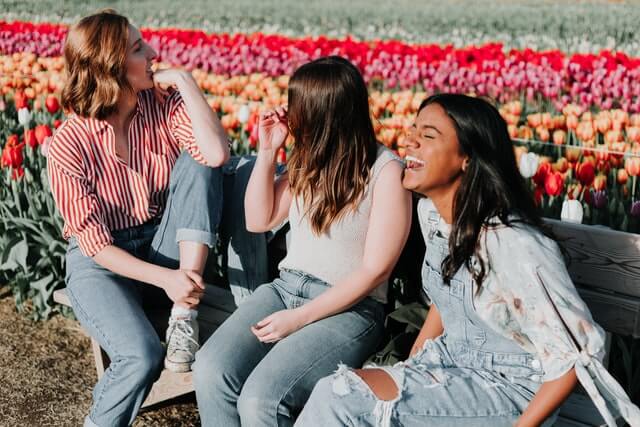 women laughing in a flower patch