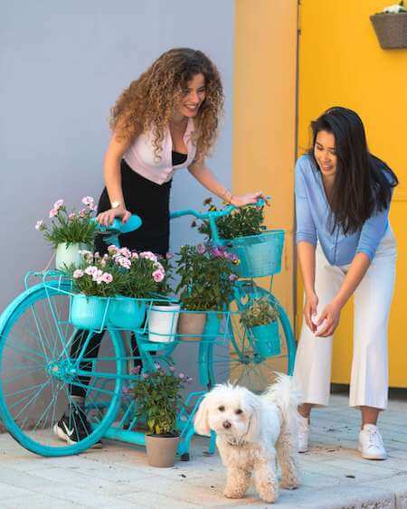 Two women with a bike and a dog.