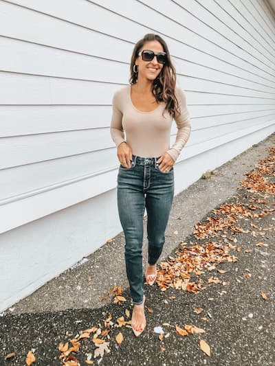 woman in good american jeans, nude bodysuit, and heels