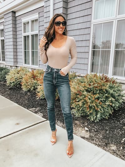 woman wearing good american jeans, a bodysuit, and clear heels