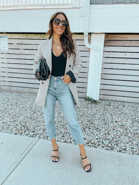 woman wearing a blazer, jeans, and black heels