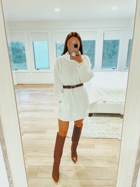 a woman wearing a white sweater dress and brown knee high boots