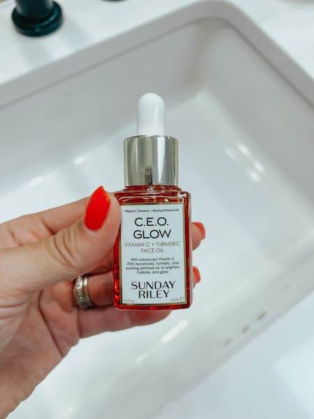 A woman holding Sunday Riley CEO Glow Face Oil
