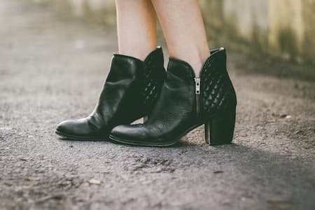 A woman wearing black ankle boots with no show socks
