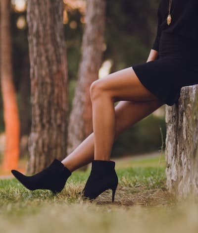 A woman wearing black ankle booties