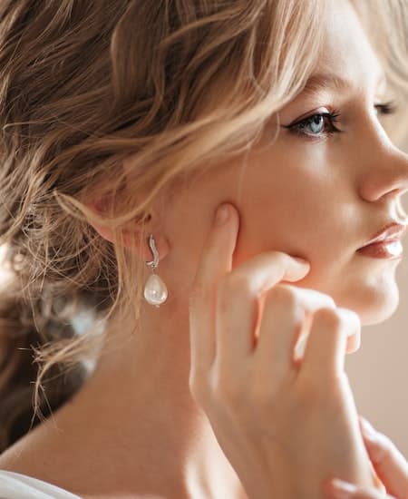 A woman wearing pearl earrings.