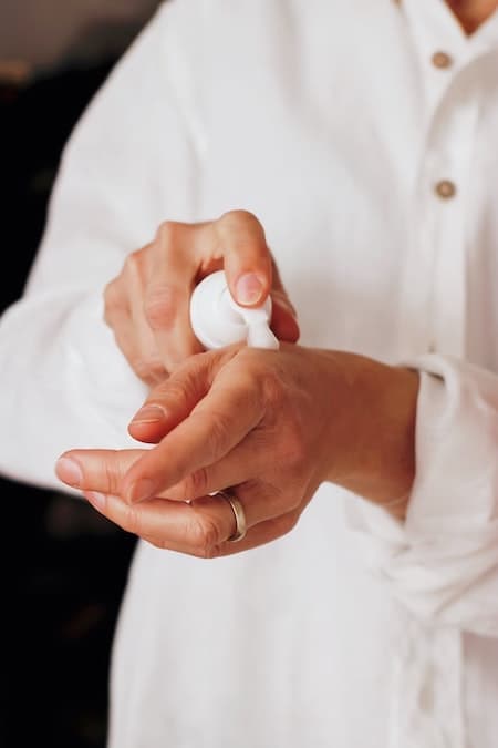 A person putting hand lotion on their hand.