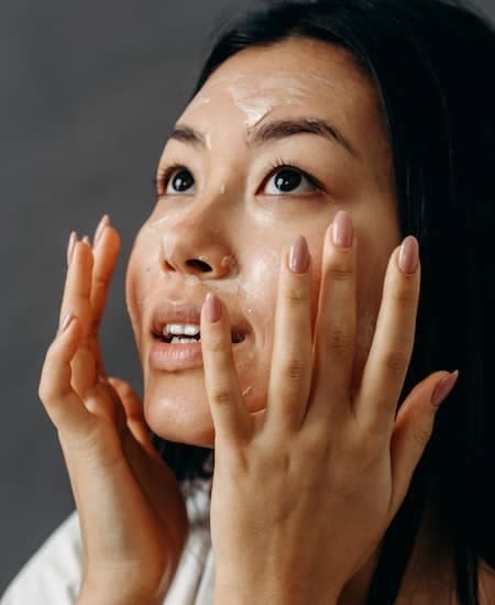 A woman exfoliating her face.