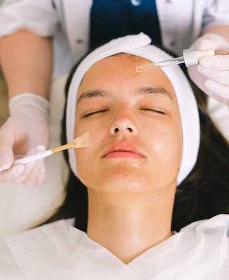 A woman having a chemical peel done on her face.