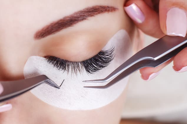 A woman having eyelash extensions applied. 