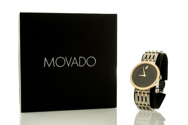 A black and gold Movado watch and a black Movado watch box.