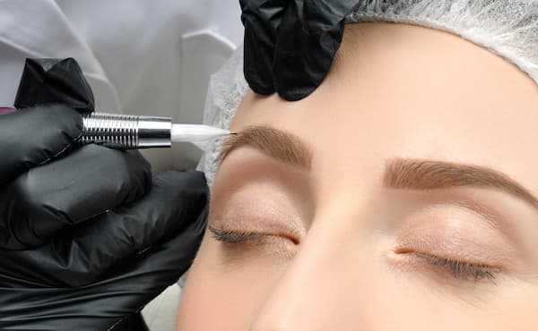 A woman having microblading done to her eyebrows.