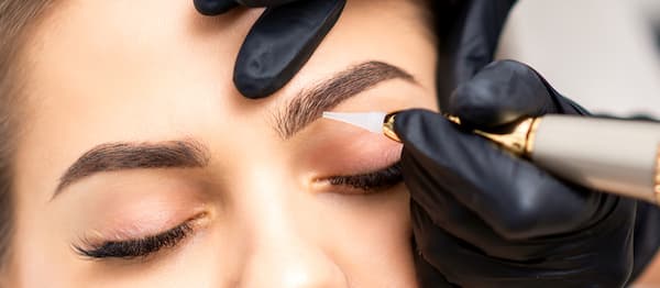 A woman getting her eyebrows microbladed.