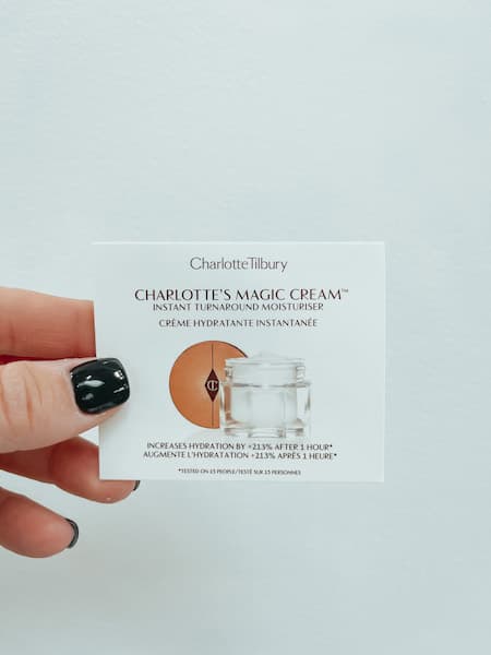 A woman holding a sample of Charlotte Tilbury "Charlotte's Magic Cream"