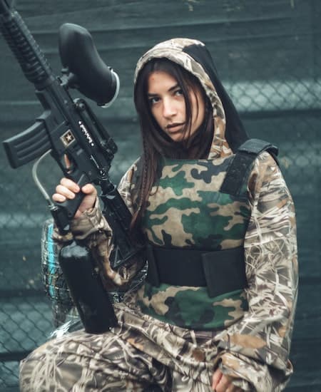 A woman in a camo paintball jumpsuit.