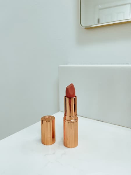 Charlotte Tilbury Matte Revolutionary lipstick sitting on a bathroom vanity.