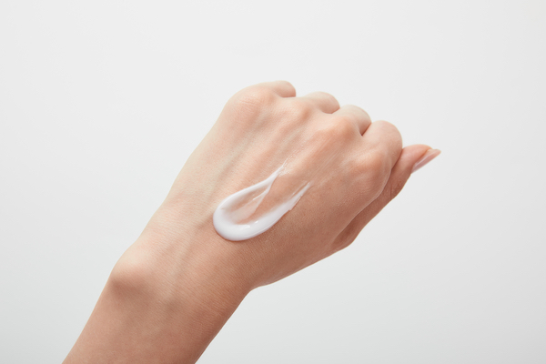 A woman with lotion on the back of her hand.