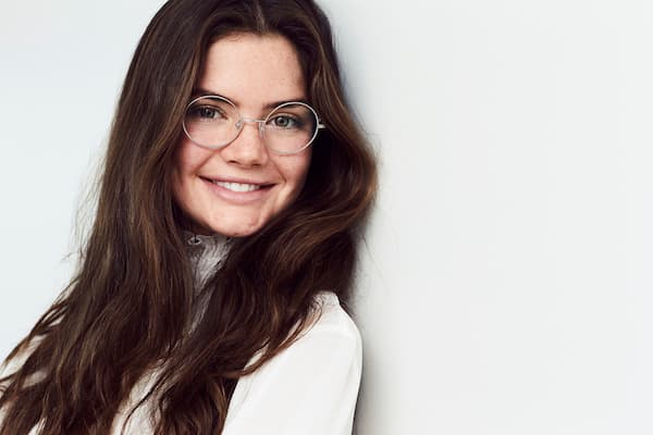 A picture of a smiling woman with brown hair wearing glasses.