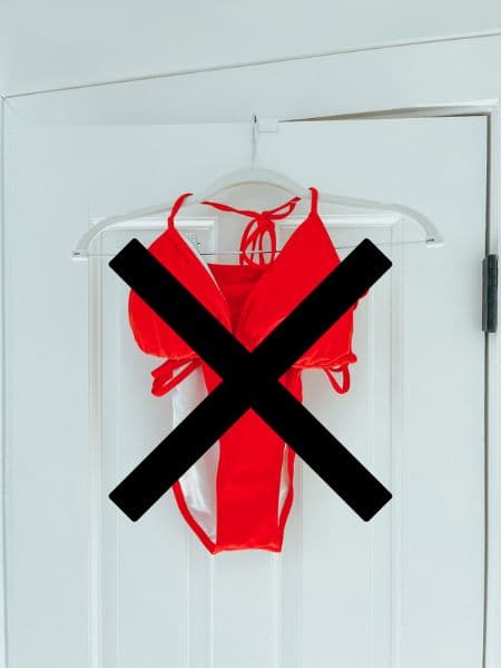 A red bathing suit on a hanger with a black x through it.