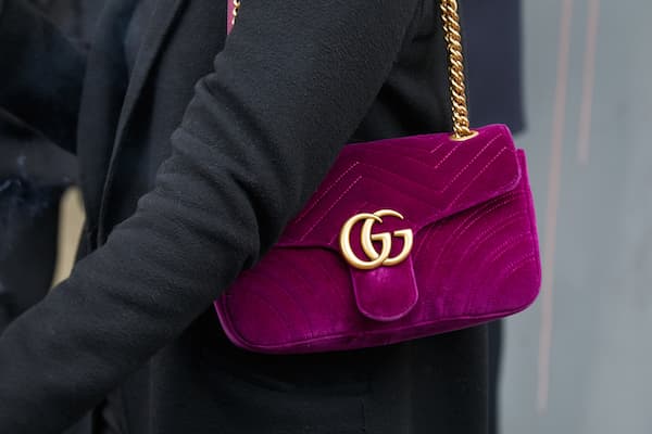 A woman with a purple Gucci bag over her shoulder.