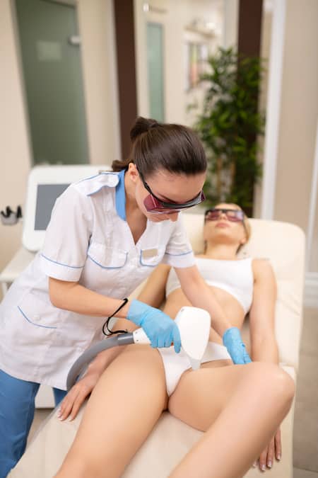 A woman having a bikini laser hair removal treatment done by a professional.