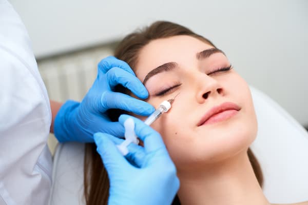 A woman having botox injected into her face.