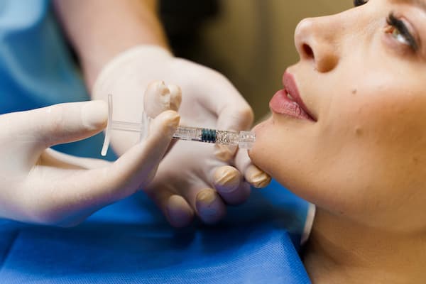 A woman having dermal filler injected into her chin.