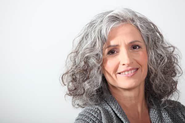 A woman with grey curly hair.