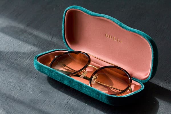 Gucci sunglasses sitting in a Gucci sunglasses case.