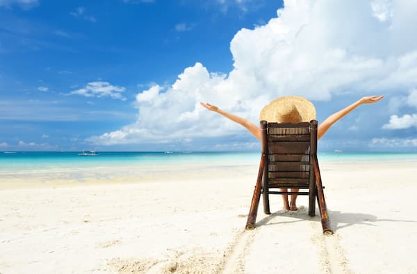 A woman sitting in a chair at the beach.