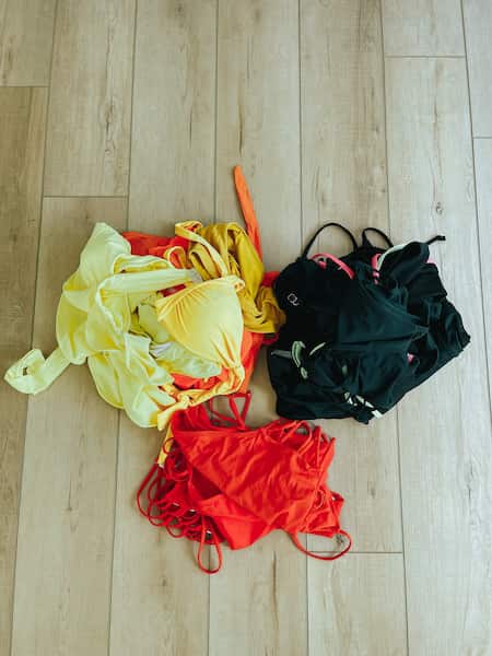 A pile of women's bathing suits separated by color.